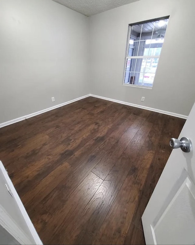 empty room with hardwood / wood-style floors and a textured ceiling