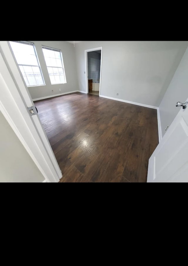 spare room with dark hardwood / wood-style flooring