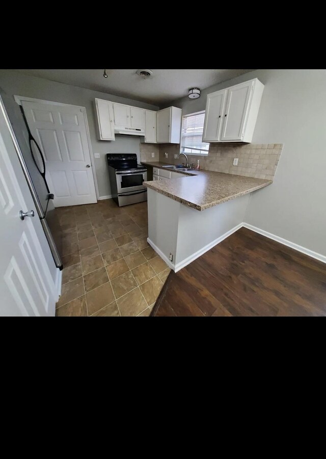 kitchen with stainless steel electric range, white cabinets, sink, dark hardwood / wood-style floors, and kitchen peninsula