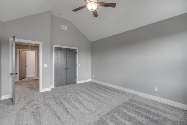 unfurnished bedroom with ceiling fan, light colored carpet, high vaulted ceiling, and a closet