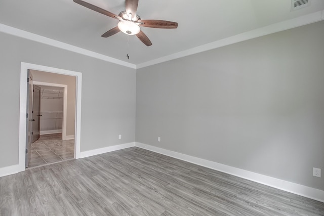 spare room with light hardwood / wood-style flooring, ceiling fan, and crown molding