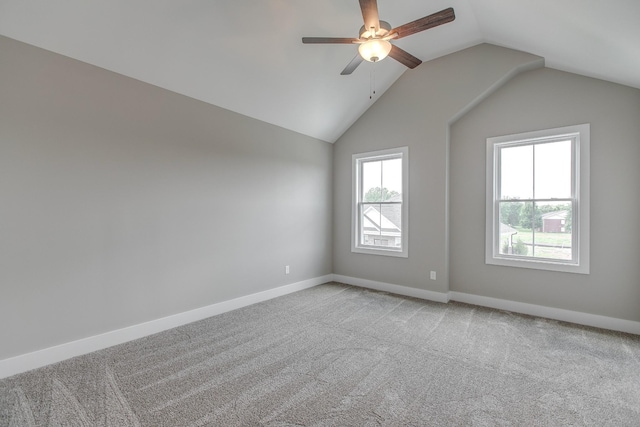 empty room with ceiling fan, carpet floors, and vaulted ceiling