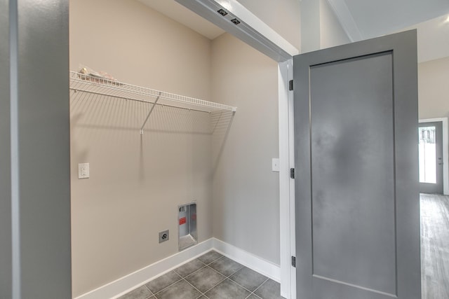 clothes washing area with hookup for an electric dryer, dark tile patterned floors, and hookup for a washing machine