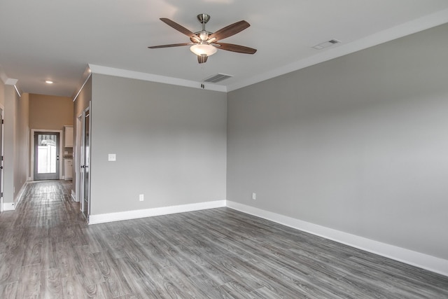 unfurnished room featuring ceiling fan, wood-type flooring, and ornamental molding