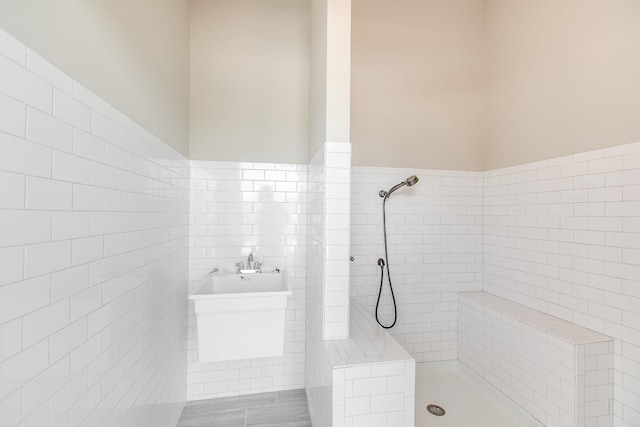 bathroom featuring plus walk in shower and tile walls