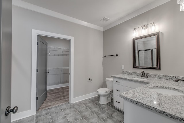 bathroom with tile patterned flooring, vanity, ornamental molding, and toilet