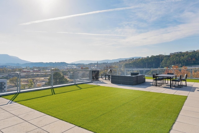 view of home's community featuring a lawn, an outdoor living space, a mountain view, and a patio