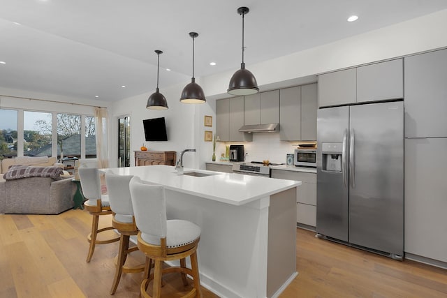 kitchen featuring stainless steel appliances, a kitchen island with sink, sink, light hardwood / wood-style flooring, and gray cabinets