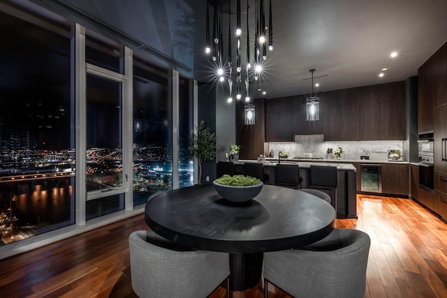 dining space featuring light hardwood / wood-style flooring and beverage cooler