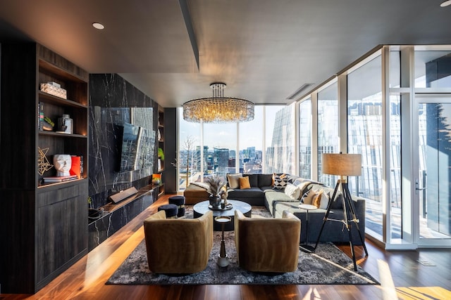 living room with hardwood / wood-style flooring, floor to ceiling windows, built in features, and a chandelier