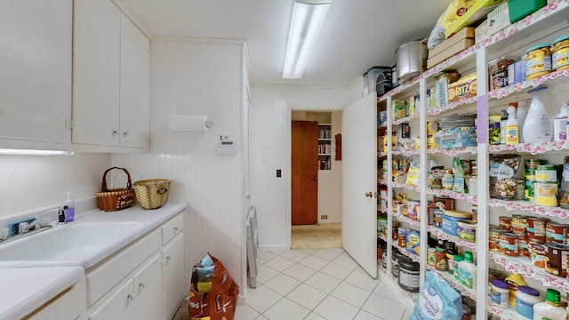 kitchen featuring white cabinets, light tile patterned floors, and sink