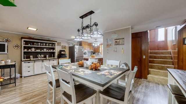 dining room featuring ceiling fan, light wood-type flooring, and crown molding