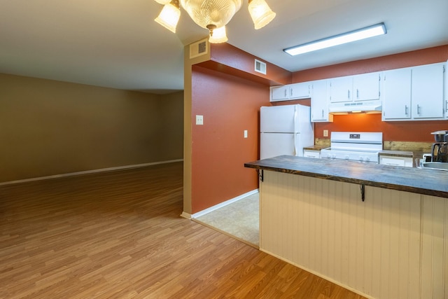 kitchen with pendant lighting, white appliances, white cabinets, light wood-type flooring, and kitchen peninsula