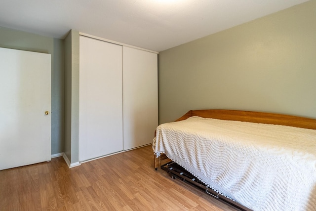 bedroom with light hardwood / wood-style flooring and a closet