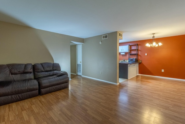 living room with wood-type flooring, sink, and a chandelier