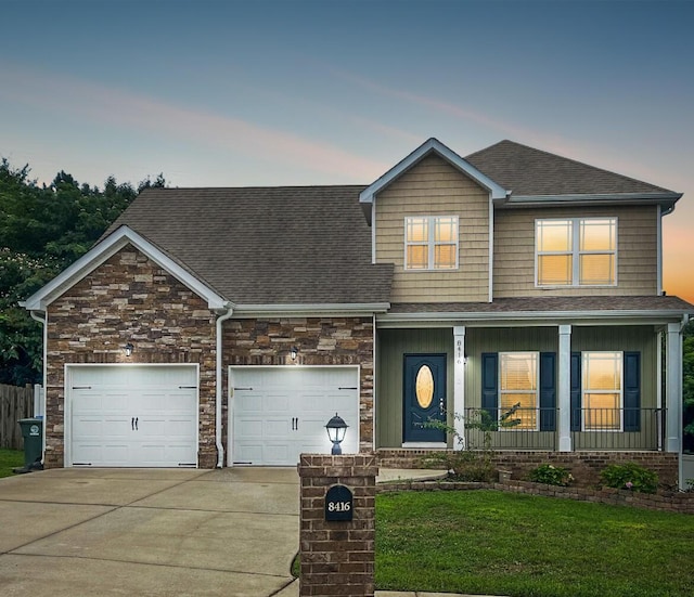 craftsman-style house featuring a yard, covered porch, and a garage