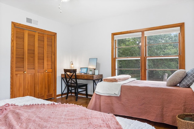 bedroom featuring dark hardwood / wood-style flooring and a closet