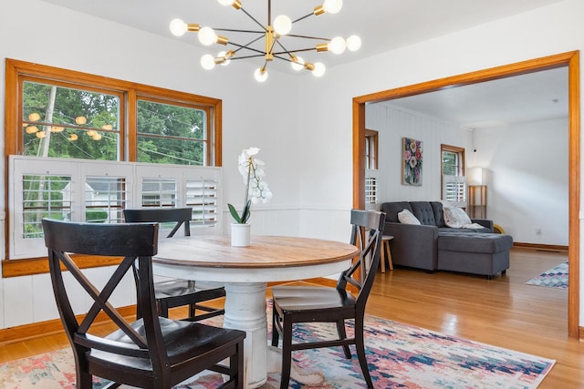 dining space with a notable chandelier and light hardwood / wood-style floors