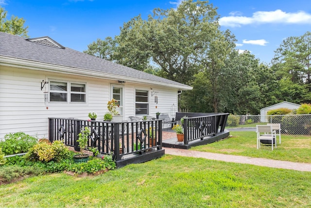 exterior space featuring a wooden deck and a lawn