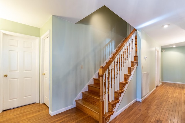 staircase with hardwood / wood-style floors