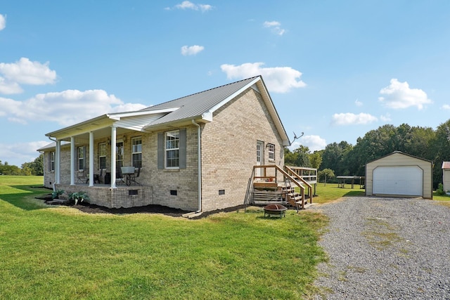 view of property exterior featuring a yard, an outbuilding, covered porch, and a garage