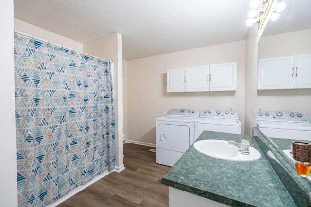 laundry area with dark hardwood / wood-style flooring, sink, and washing machine and clothes dryer