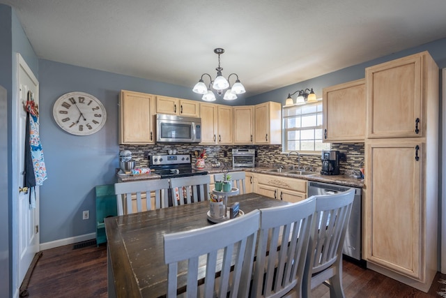 kitchen with decorative light fixtures, sink, stainless steel appliances, and light brown cabinetry