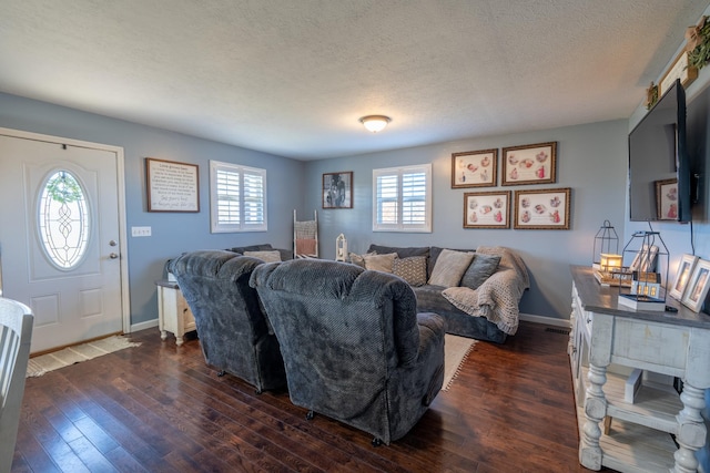 living room featuring dark wood-type flooring, a healthy amount of sunlight, and a textured ceiling