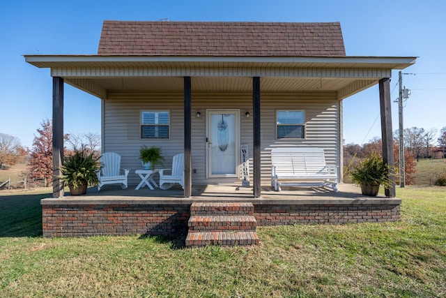 bungalow featuring covered porch and a front yard