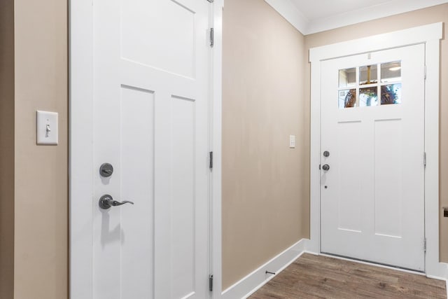 entryway with ornamental molding and dark wood-type flooring