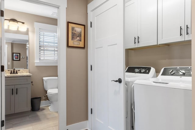 washroom with washer and dryer, light hardwood / wood-style floors, and sink