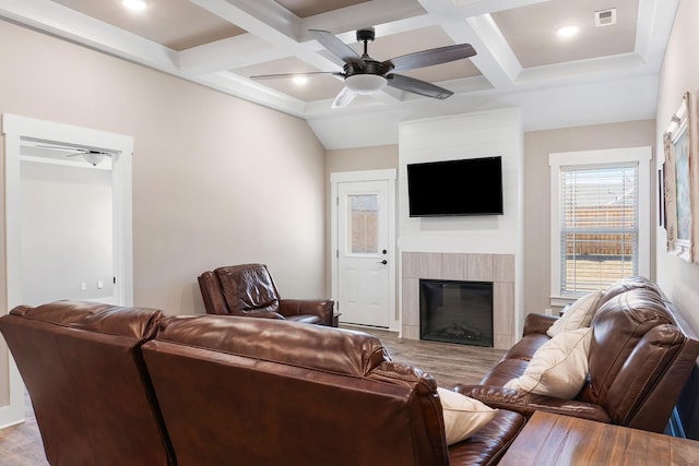 living room featuring hardwood / wood-style flooring, beamed ceiling, a tile fireplace, and coffered ceiling