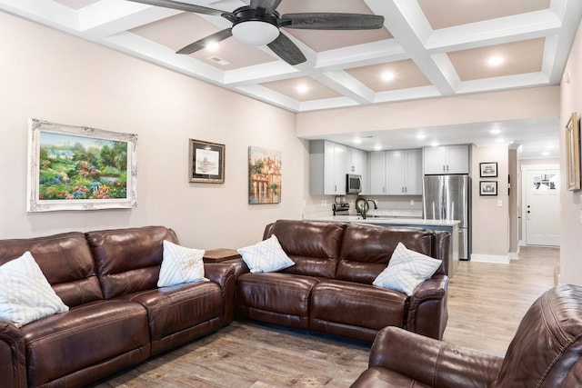 living room with coffered ceiling, ceiling fan, sink, beam ceiling, and light hardwood / wood-style flooring