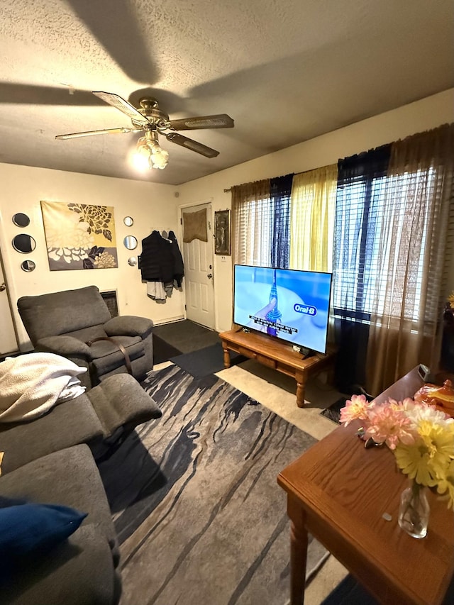 living room with ceiling fan and a textured ceiling