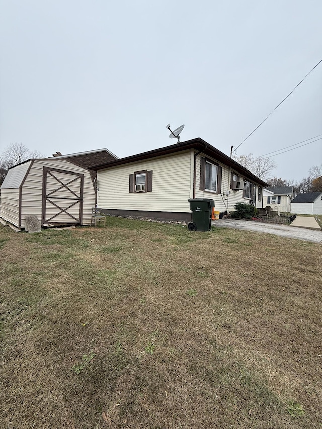 view of home's exterior with a yard and a storage unit