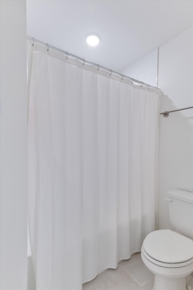 bathroom with toilet and tile patterned floors