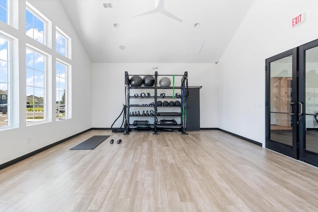 workout area with ceiling fan, light hardwood / wood-style flooring, and high vaulted ceiling