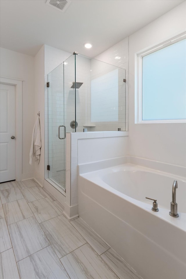 bathroom featuring independent shower and bath