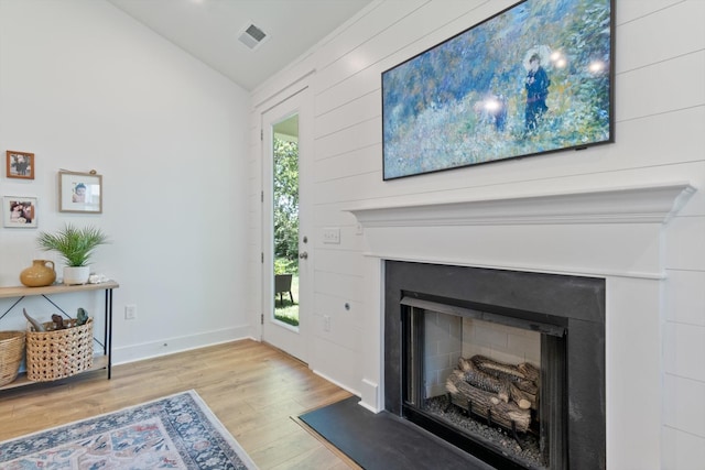 living room featuring lofted ceiling and light hardwood / wood-style flooring