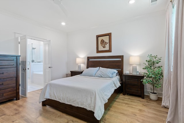 bedroom featuring ensuite bathroom, ceiling fan, ornamental molding, and light wood-type flooring