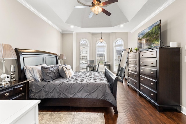 bedroom with dark wood-type flooring, a raised ceiling, a ceiling fan, and crown molding