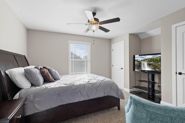 carpeted bedroom with ceiling fan and baseboards