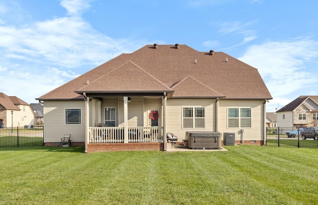 back of house featuring crawl space, a hot tub, a lawn, and central AC