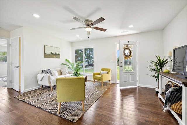 living room featuring ceiling fan and dark hardwood / wood-style flooring