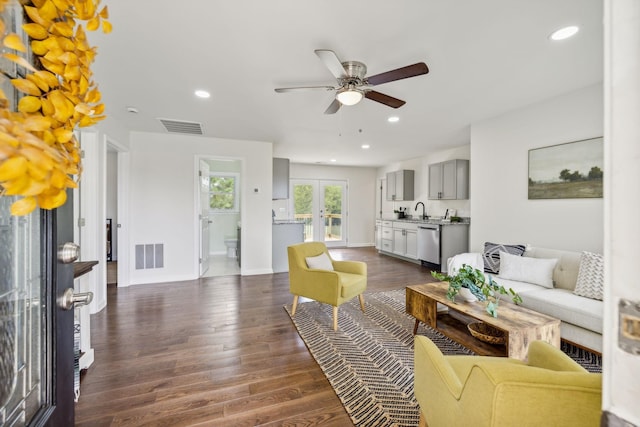 living room featuring dark hardwood / wood-style floors, ceiling fan, and sink