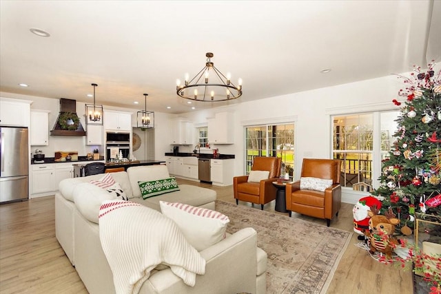 living room with light wood-type flooring and an inviting chandelier