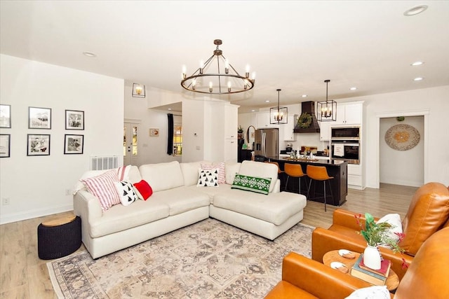 living room featuring a chandelier and light wood-type flooring