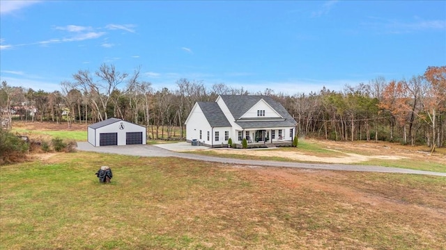 view of front facade with covered porch, a garage, a front lawn, and an outdoor structure