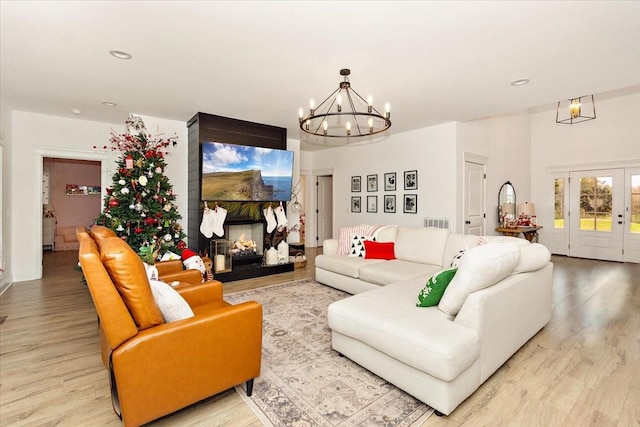 living room with light hardwood / wood-style floors and an inviting chandelier