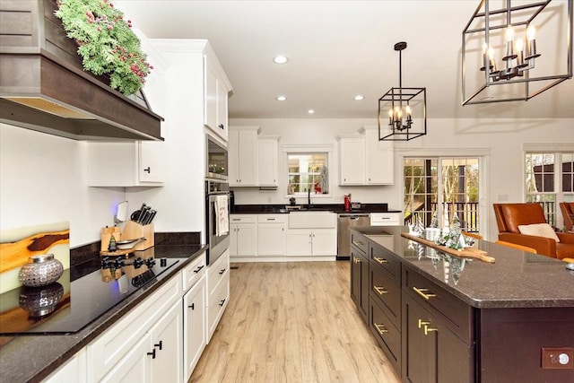 kitchen featuring stainless steel appliances, light hardwood / wood-style flooring, a kitchen island, and hanging light fixtures